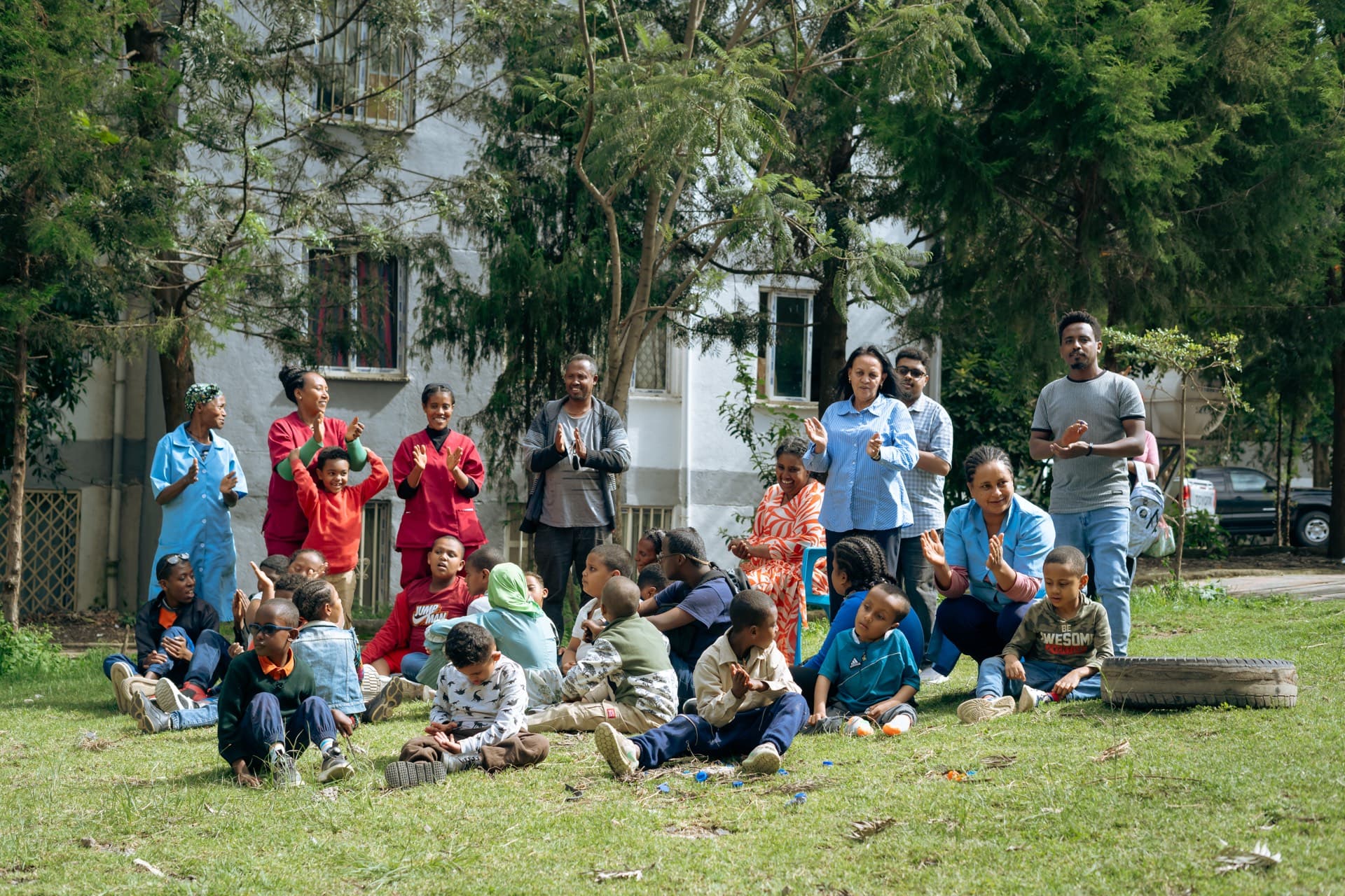 Children and caregivers smiling together outdoors